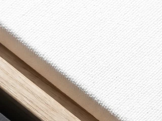 Close view of textured canvas, a natural wood frame and the shadow gap between them